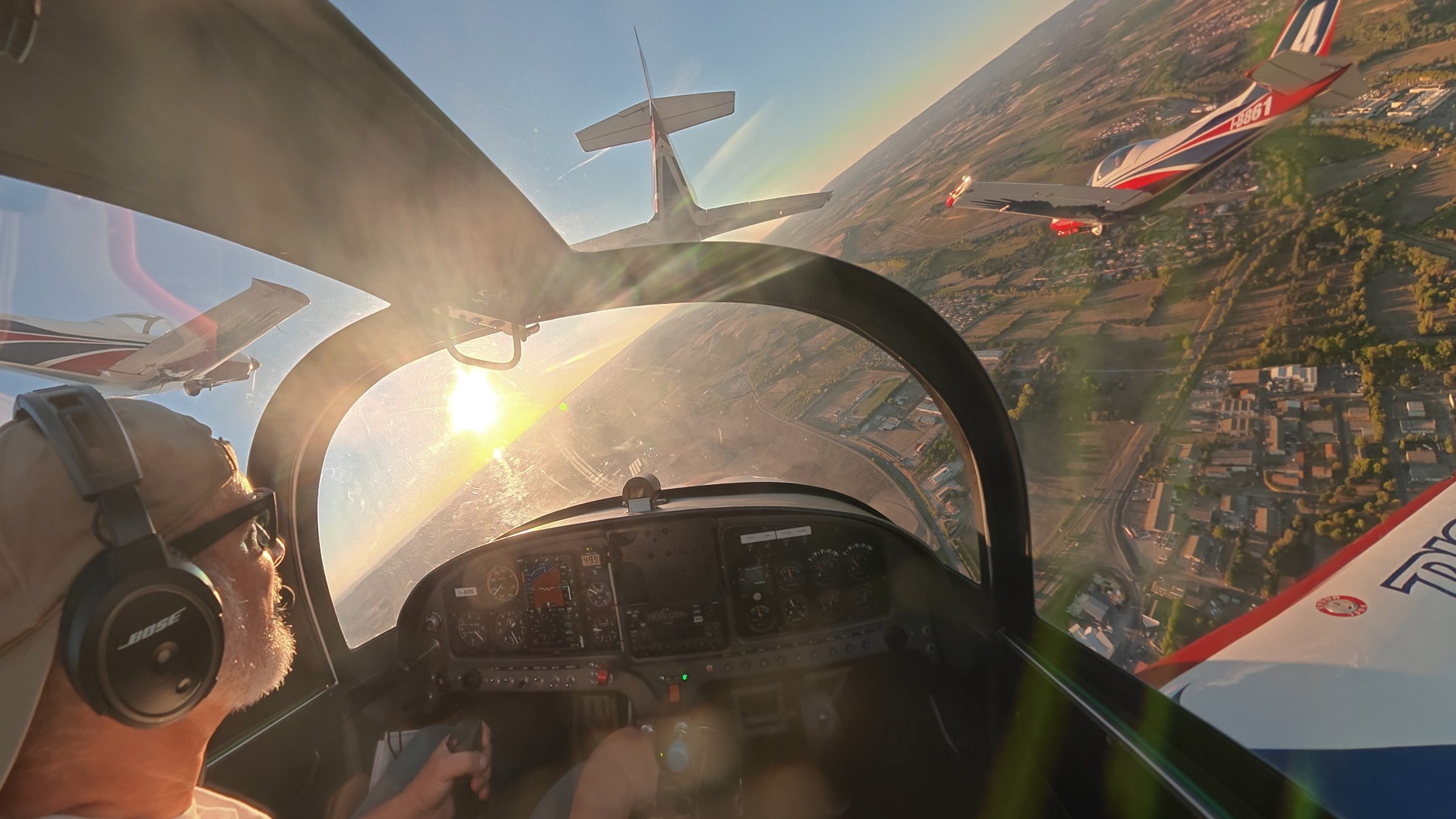 Tre aerei in formazione visti dalla cabina, al tramonto